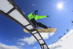 Snowboarder on rail at snow