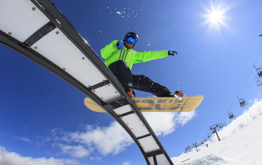 Snowboarder on rail at snow